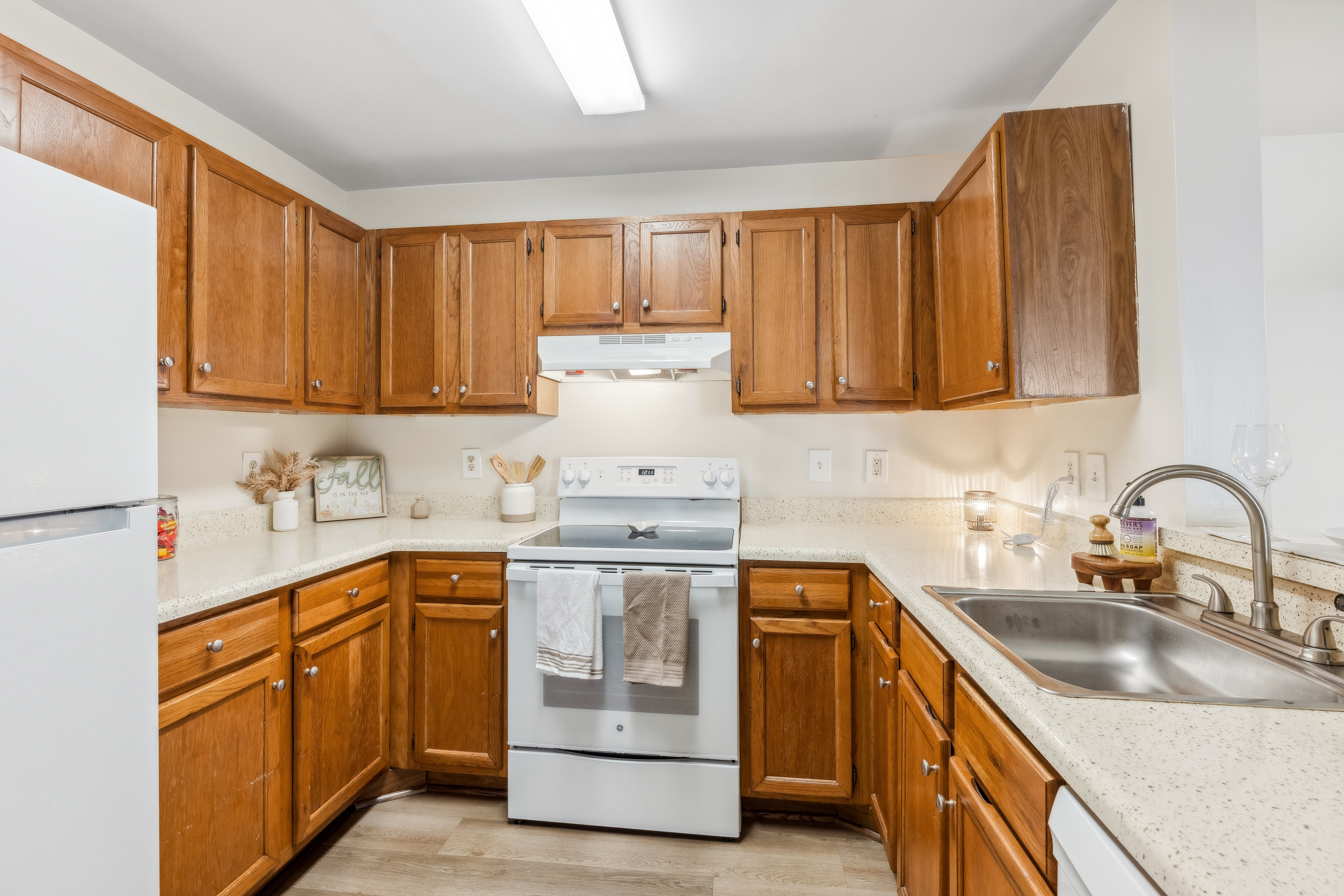 A kitchen with wooden cabinets and a white refrigerator.